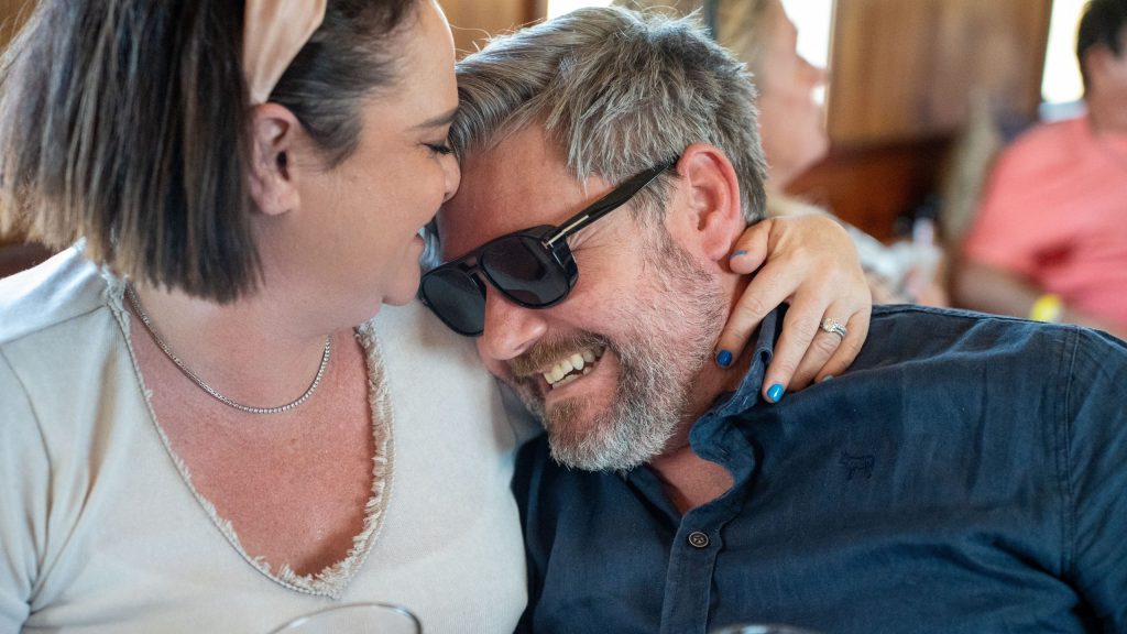 A couple laughing together at a restaurant.