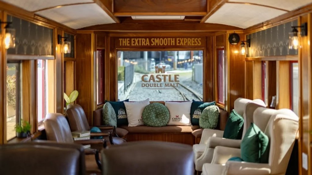 Luxurious train interior with cushioned seating and pillows under soft lighting.